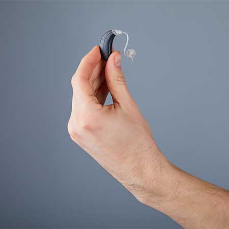 Man holding a new style hearing aid